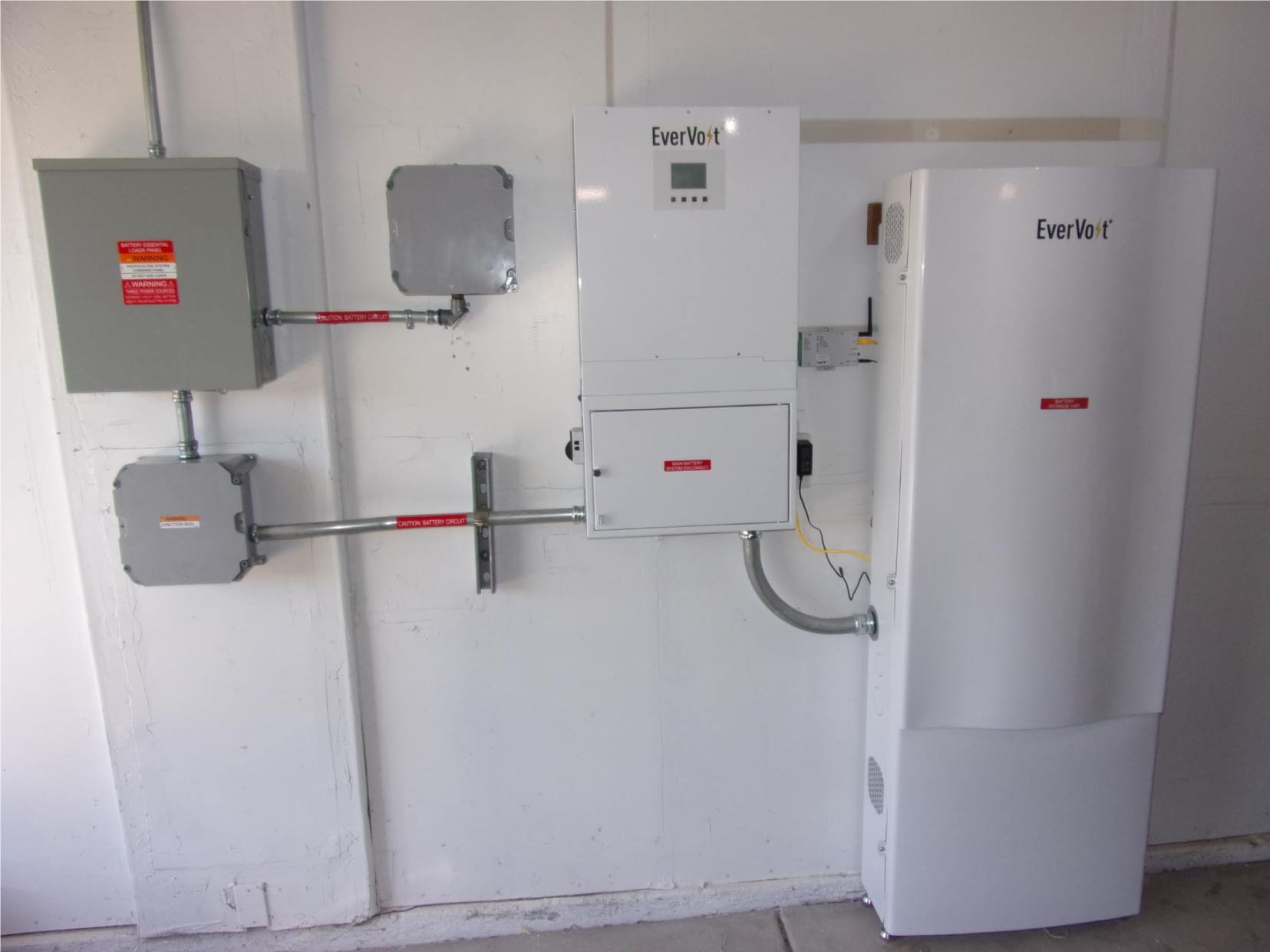 A complete EverVolt residential solar battery backup system with inverter neatly installed inside a garage.