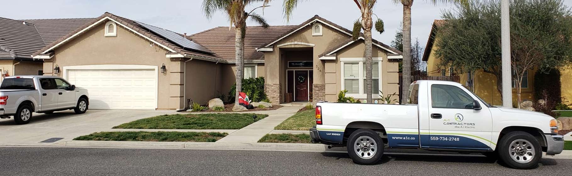 Exterior view of a Central Valley house with a completed solar panel installation and an A-1 Contractors service truck parked outside, illustrating residential home upgrades.