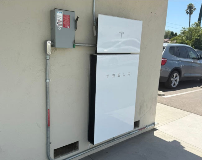 A residential Tesla Powerwall solar battery system expertly installed on a home's exterior for energy independence.