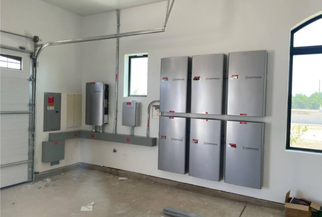 A professional garage installation of multiple Enphase IQ solar battery backup units for reliable home energy.