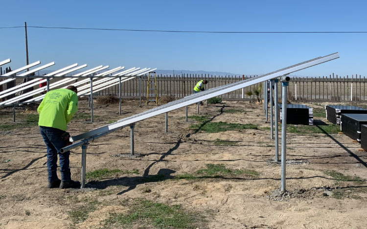 The A-1 Contractors team building the framework for a large ground-mount solar panel array installation.