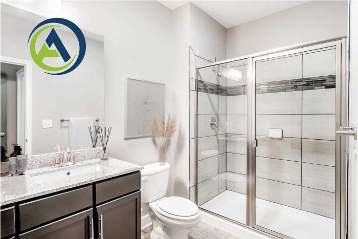 Freshly completed, modern bathroom remodel featuring a dark granite vanity, white subway tile shower, and glass enclosure, ready for inspection by a local contractor.