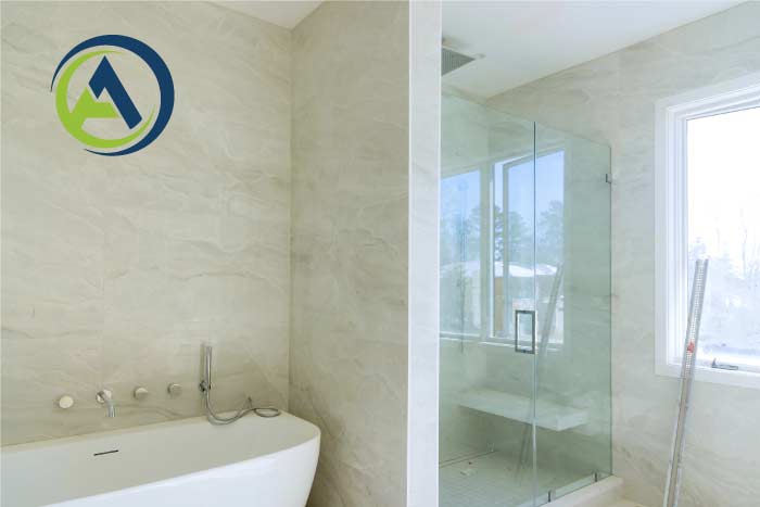 Almost-finished residential bathroom remodel showing a freestanding soaking tub and large walk-in glass shower enclosure against light marble-patterned wall tiles.