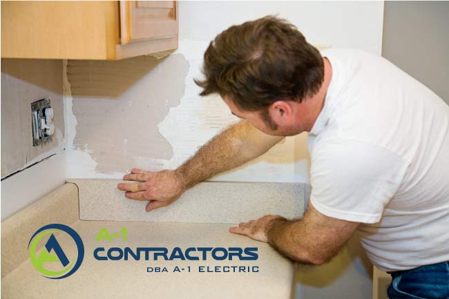 A-1 Contractors specialist installing a custom countertop backsplash during a kitchen renovation project to ensure a professional finish